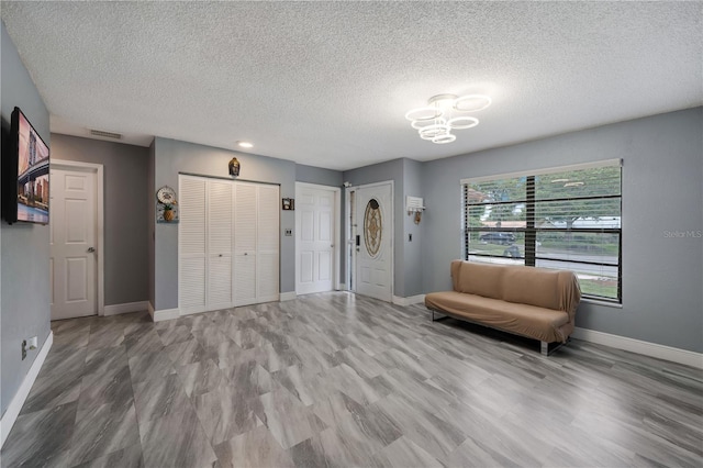 unfurnished room with hardwood / wood-style floors and a textured ceiling