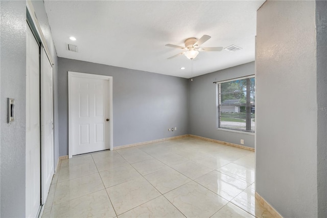 spare room featuring ceiling fan and light tile patterned floors