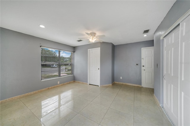 unfurnished bedroom with ceiling fan and light tile patterned floors