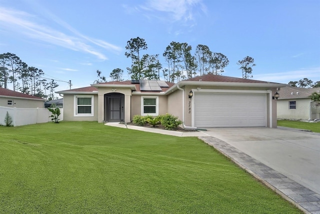 ranch-style home featuring a garage, solar panels, and a front yard