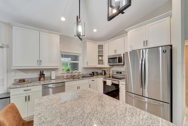 kitchen with white cabinets, hanging light fixtures, appliances with stainless steel finishes, and sink