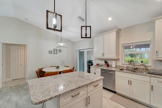 kitchen with decorative light fixtures, white cabinets, sink, dishwasher, and vaulted ceiling