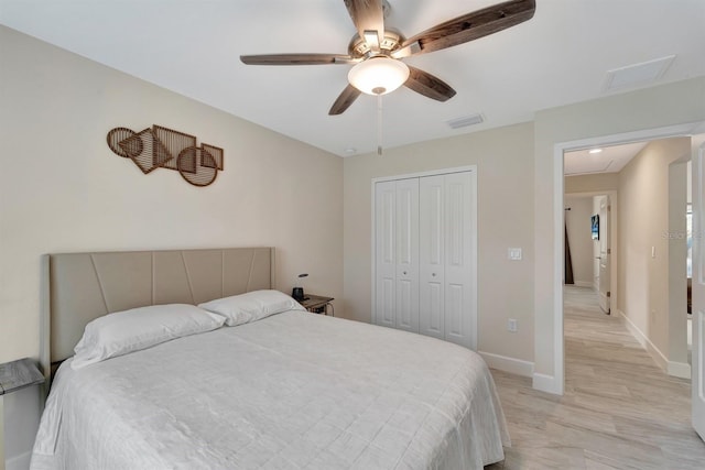 bedroom with light hardwood / wood-style flooring, a closet, and ceiling fan