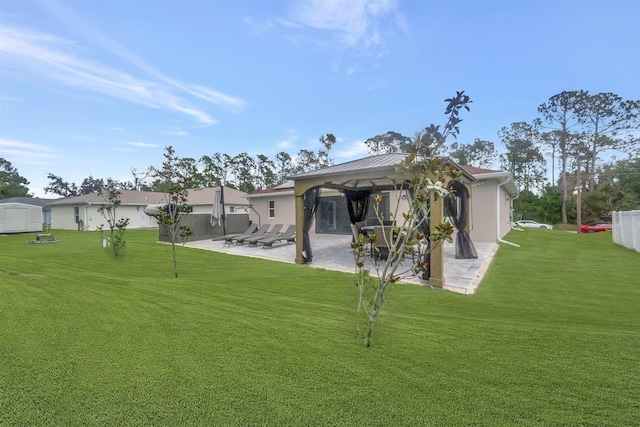 back of house featuring a lawn, a patio area, and a gazebo