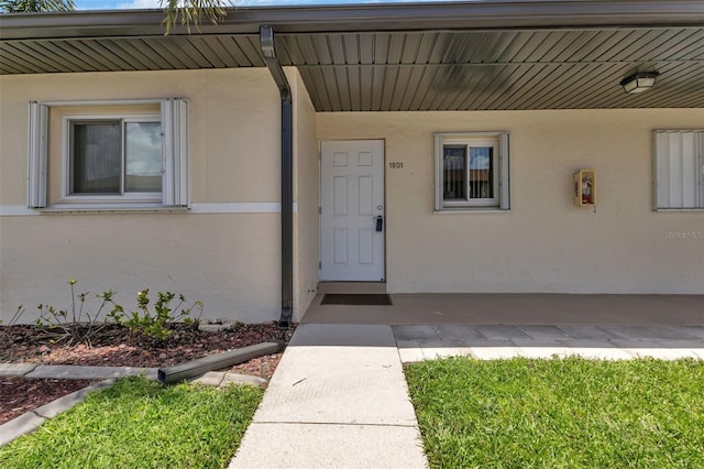 doorway to property featuring stucco siding