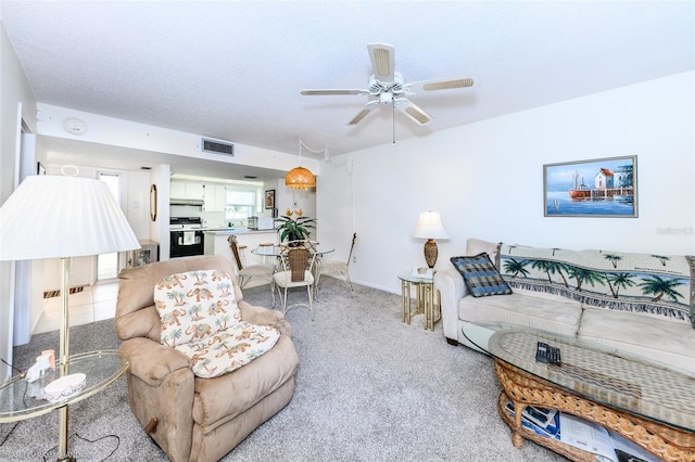 carpeted living room featuring a textured ceiling and ceiling fan