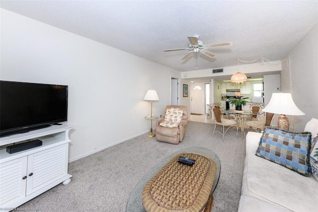 carpeted living room featuring a textured ceiling and ceiling fan