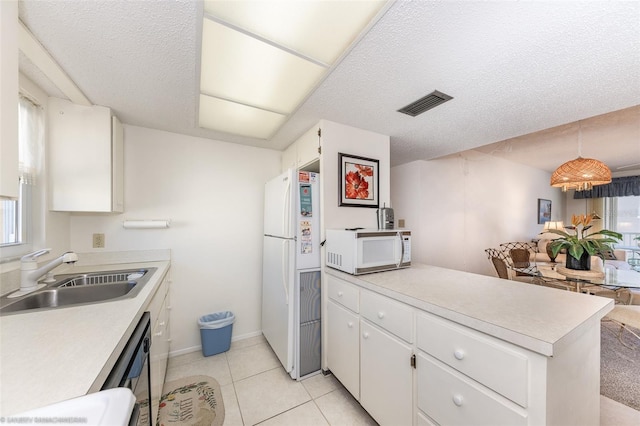 kitchen with hanging light fixtures, white appliances, sink, and a textured ceiling