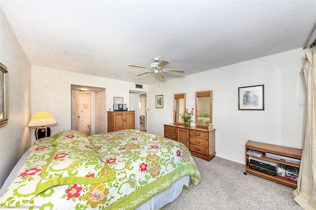 bedroom featuring ceiling fan, light carpet, and a textured ceiling