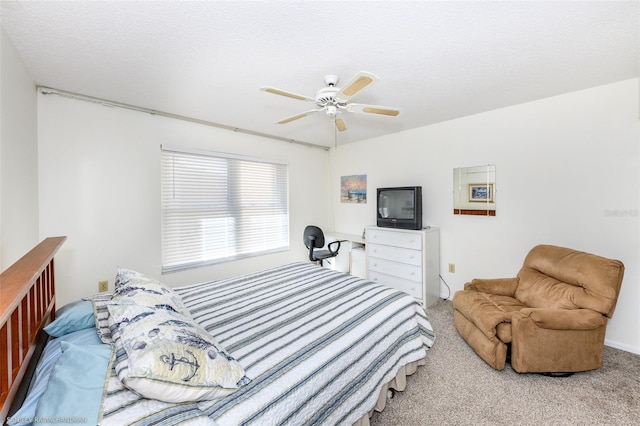 bedroom with ceiling fan, carpet, and a textured ceiling