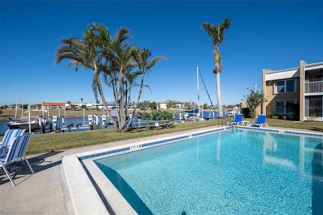 view of swimming pool featuring a yard and a water view