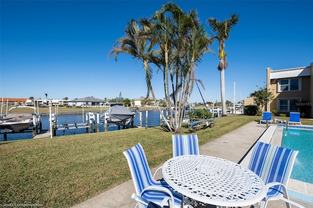 dock area with a patio area, a yard, and a water view