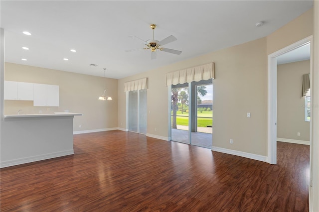 unfurnished living room featuring dark hardwood / wood-style floors and ceiling fan with notable chandelier