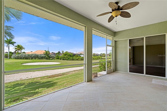 unfurnished sunroom featuring ceiling fan