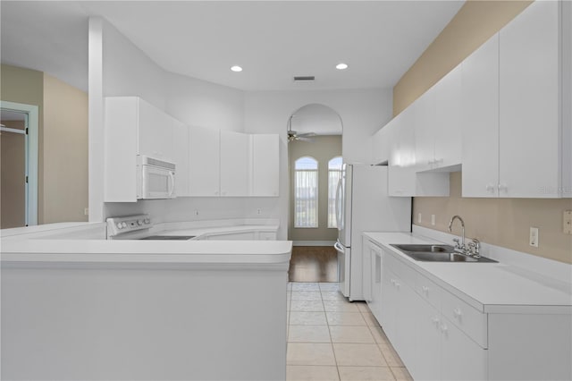 kitchen with sink, range, white cabinets, and kitchen peninsula