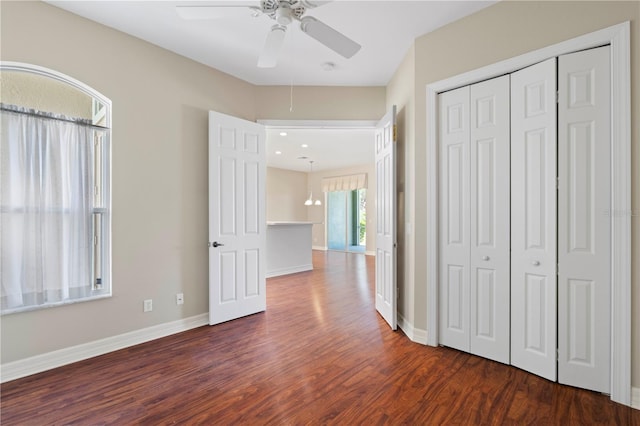 unfurnished bedroom featuring ceiling fan, dark hardwood / wood-style flooring, and a closet