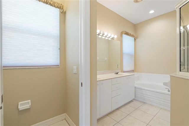 bathroom with a tub to relax in, tile patterned floors, and vanity