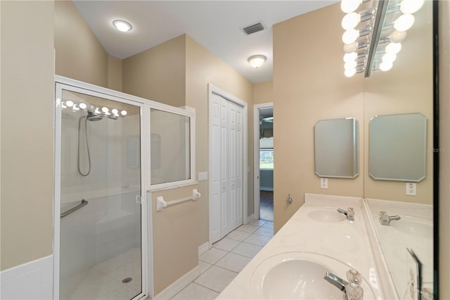 bathroom featuring a shower with door, vanity, and tile patterned floors