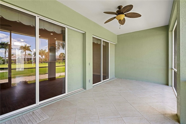 unfurnished sunroom with ceiling fan