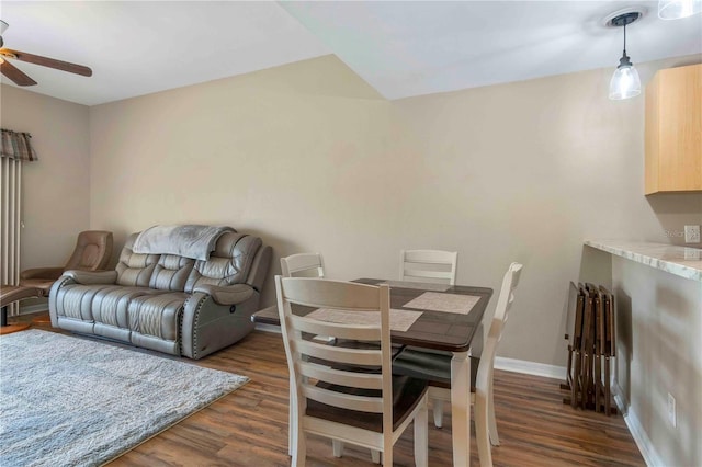 dining space featuring ceiling fan, dark wood finished floors, and baseboards