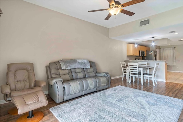 living room with ceiling fan and light hardwood / wood-style flooring