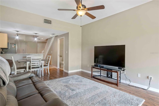 living room with wood-type flooring and ceiling fan