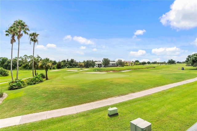 surrounding community featuring view of golf course and a yard