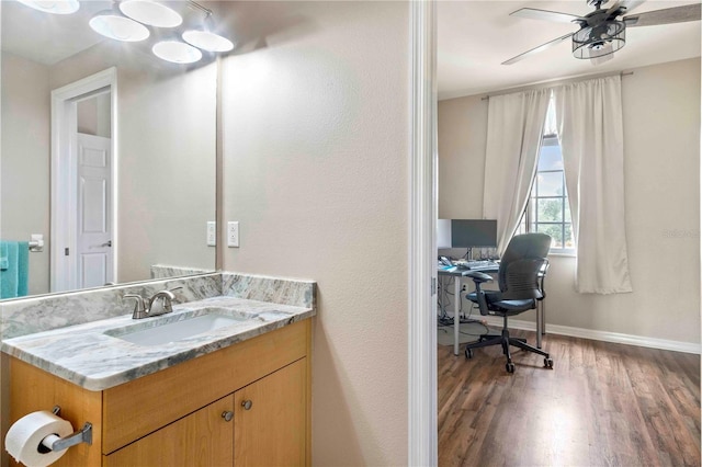 bathroom featuring baseboards, a ceiling fan, wood finished floors, and vanity