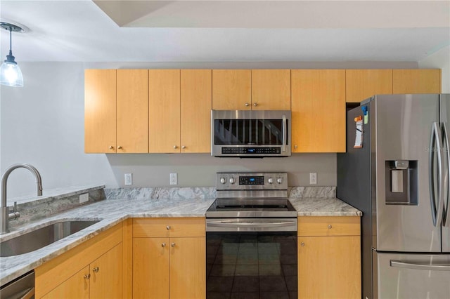 kitchen with light stone counters, sink, and appliances with stainless steel finishes