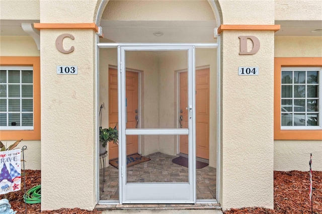 entrance to property featuring stucco siding