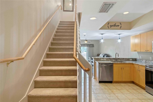 stairway featuring sink, tile patterned floors, and ceiling fan