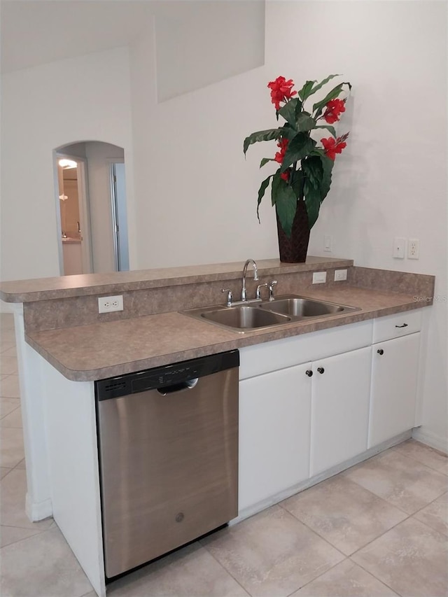 kitchen with sink, light tile patterned floors, white cabinetry, and dishwasher