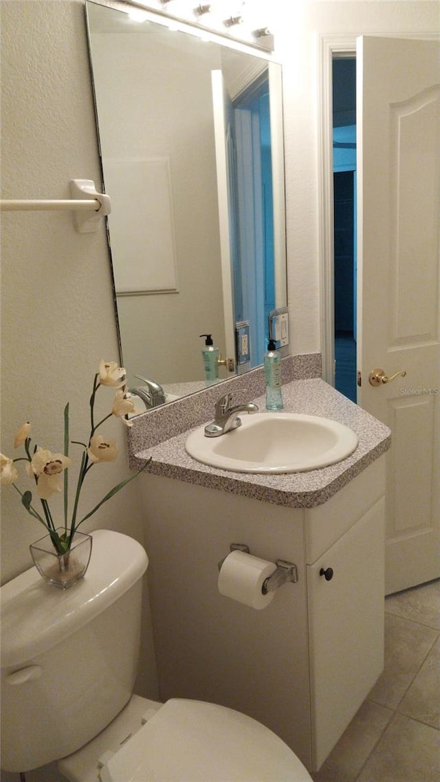 bathroom with vanity, toilet, and tile patterned floors