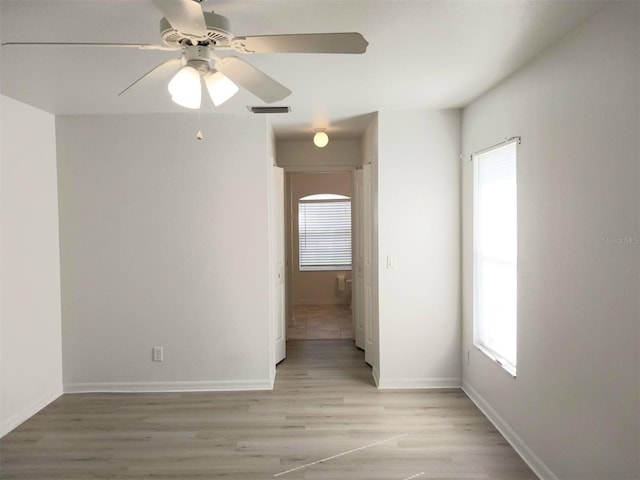 empty room with light hardwood / wood-style flooring and ceiling fan