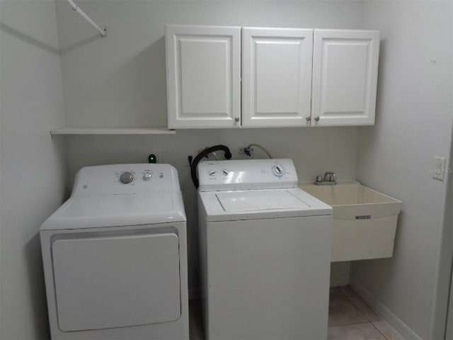 laundry room featuring sink, washer and clothes dryer, cabinets, and tile patterned flooring