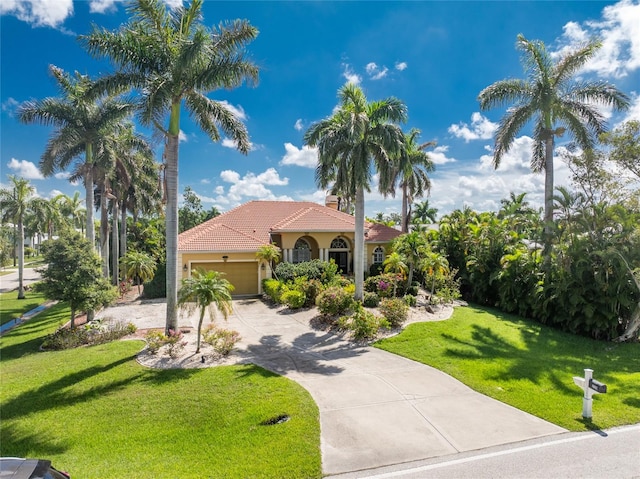 mediterranean / spanish house featuring a garage and a front lawn