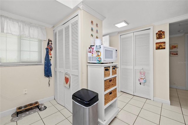 interior space with light tile patterned flooring and ornamental molding