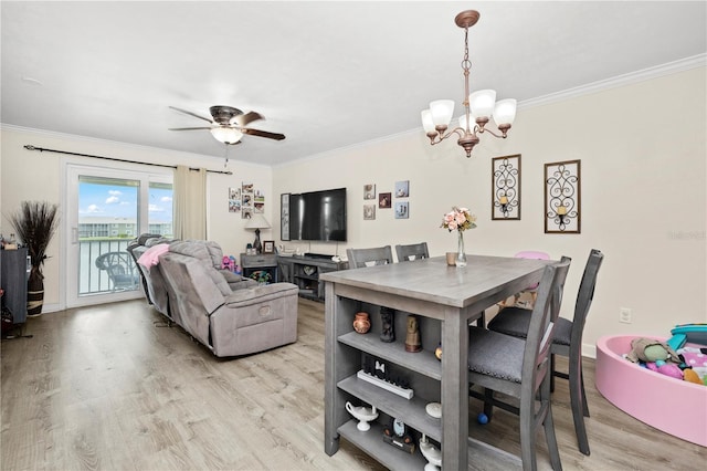 dining room with light wood-type flooring, ceiling fan with notable chandelier, and ornamental molding