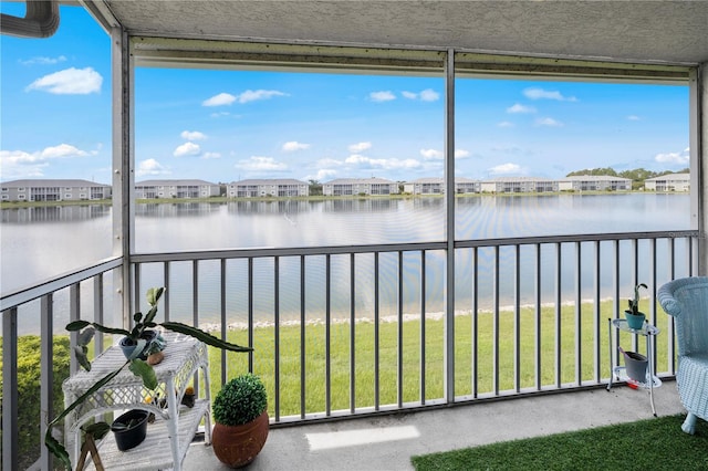 unfurnished sunroom featuring a water view