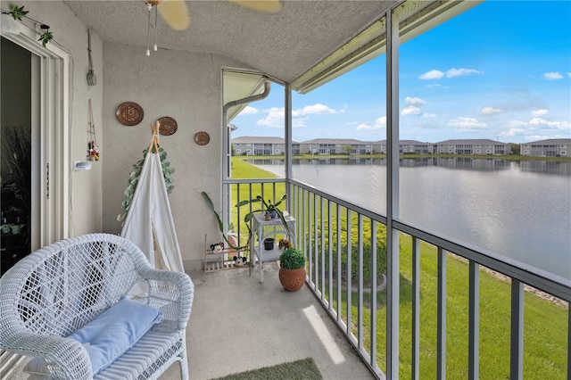 sunroom / solarium with a water view and ceiling fan