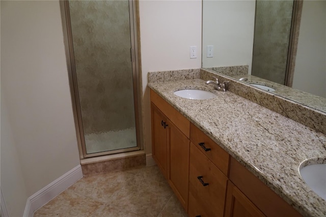 bathroom with a stall shower, tile patterned flooring, baseboards, and vanity