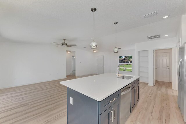 kitchen with appliances with stainless steel finishes, light hardwood / wood-style flooring, sink, a kitchen island with sink, and ceiling fan