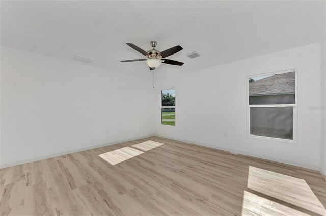 empty room with ceiling fan and light wood-type flooring