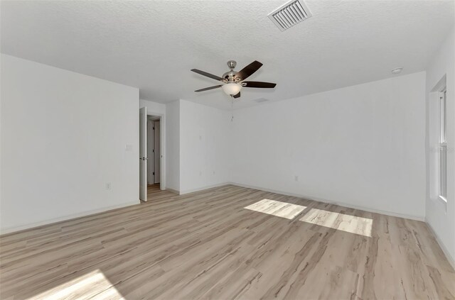 spare room featuring a textured ceiling, ceiling fan, and light hardwood / wood-style floors