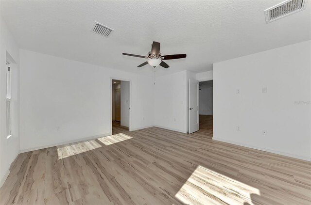 spare room featuring a textured ceiling, ceiling fan, and light hardwood / wood-style floors