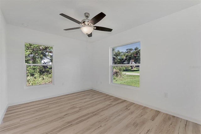 empty room with ceiling fan and light hardwood / wood-style flooring