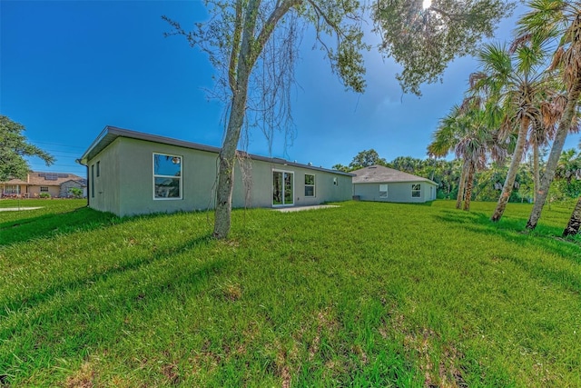 rear view of house featuring a yard