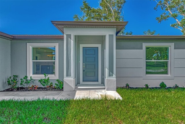 entrance to property featuring a yard