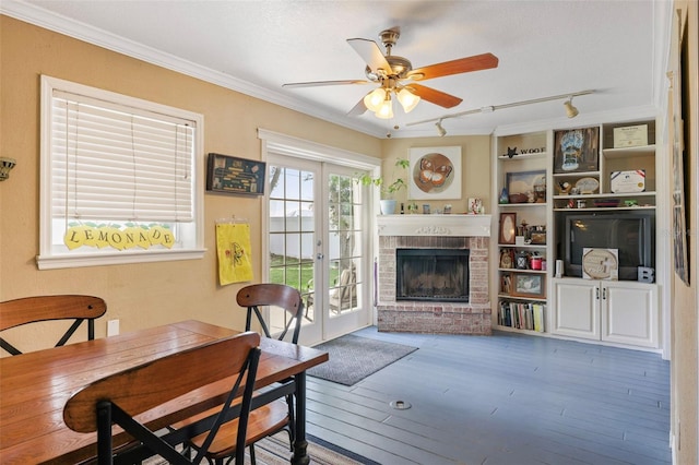 living room featuring ceiling fan, a fireplace, wood-type flooring, french doors, and crown molding