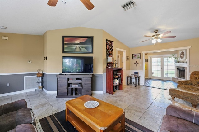 living room with vaulted ceiling, light tile patterned floors, and french doors